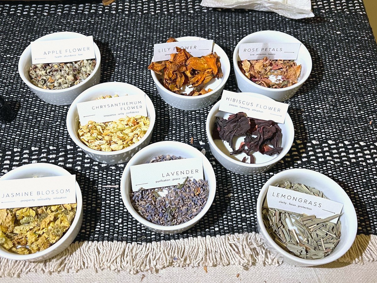 Small white bowls of dried herbs and petals, each labeled
