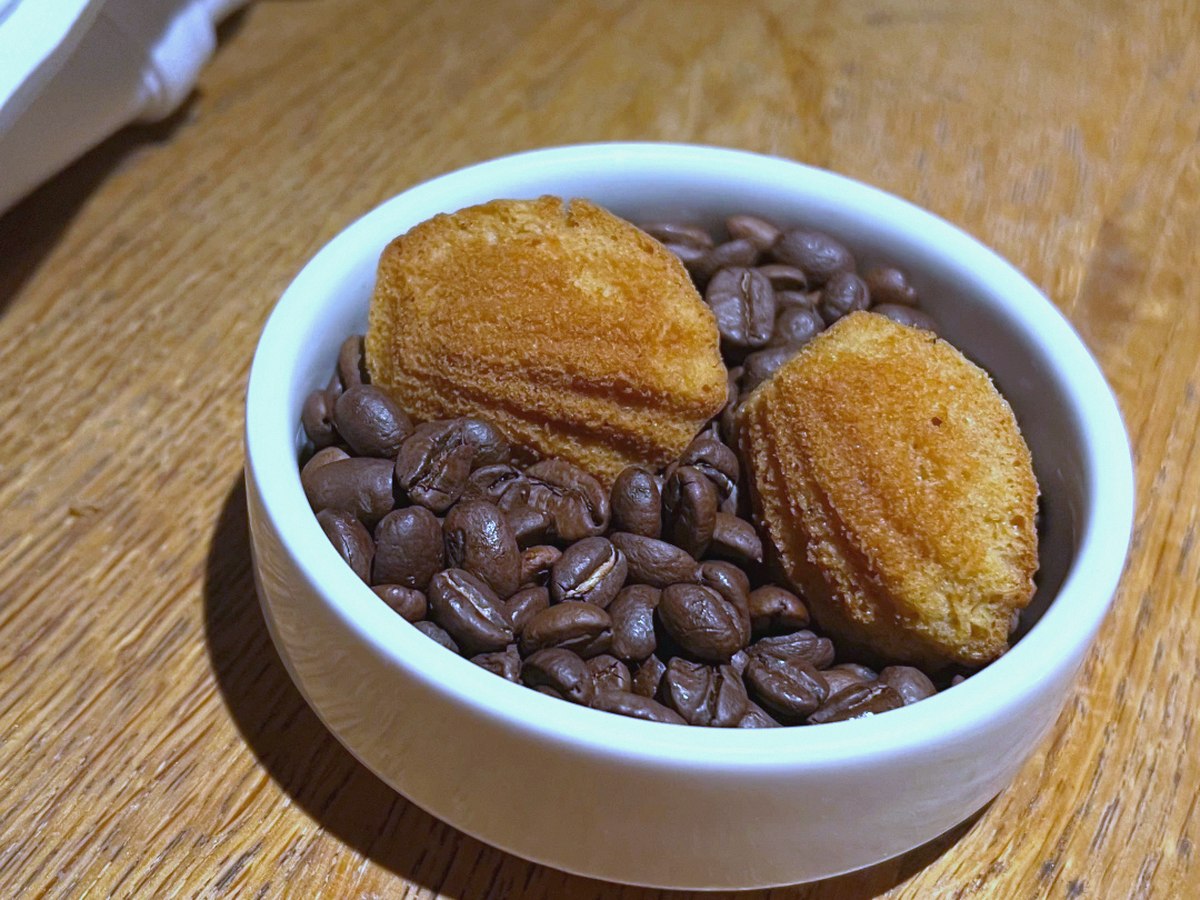 Madeleines in a bowl beside a cup of coffee
